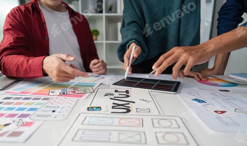 Preview: Team members actively discuss design elements on a digital tablet.