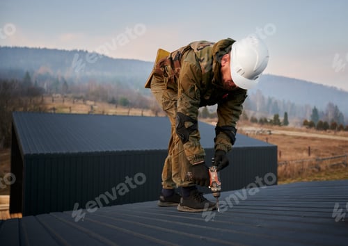Preview: Builder installing corrugated iron sheet used as facade of future wooden frame house.