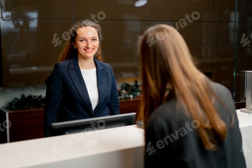 Preview: The receptionist at counter meets the guest with luggage in the hotel business travel hospitality