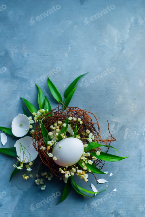 Preview: Floral Easter decoration concept with white eggs in a nest, green leaves and spring gypsophila