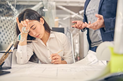 Preview: Tired brunette female person sitting at her workplace