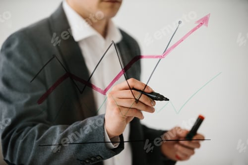Preview: Businessman drawing rising financial chart on glass board