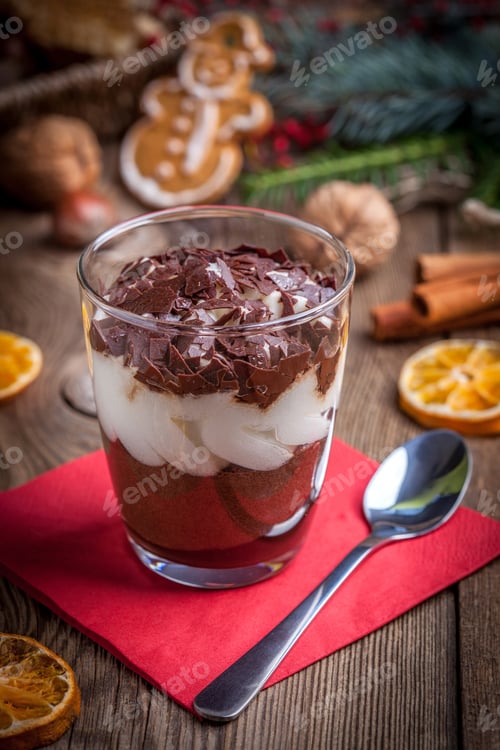 Preview: Layered dessert in a glass on a wooden table.