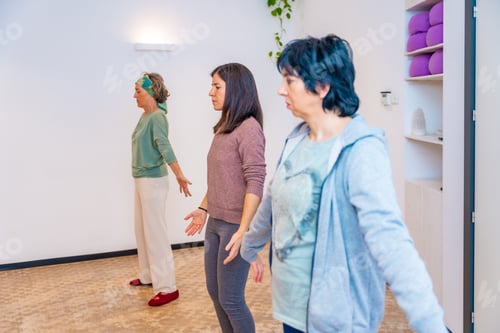 Preview: Women with arms opened breathing during qi gong class