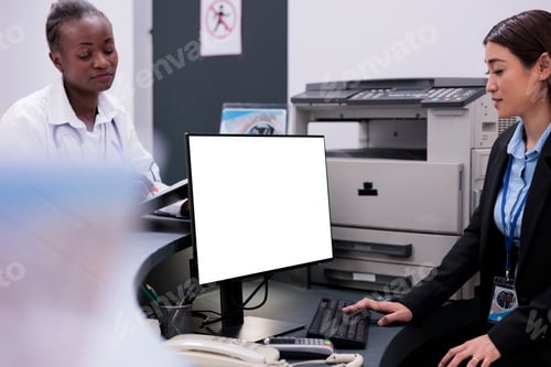 Preview: Asian reception worker using white screen on computer while working at hospital registration