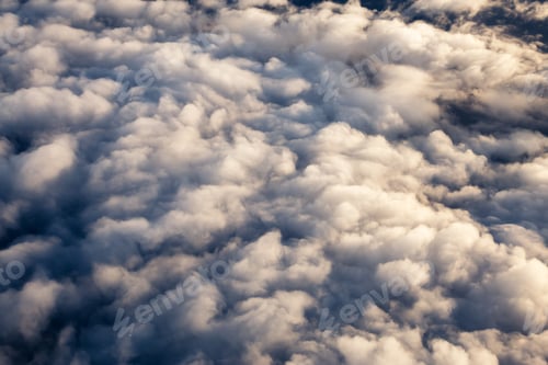 Preview: Aerial view from above a white and puffy clouds during a sunny sunrise