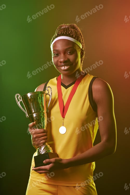 Preview: Smiling Black Woman as Female Athlete Holding Trophy