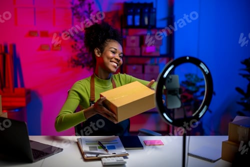 Preview: A woman is smiling while holding a cardboard box