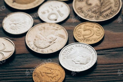 Preview: close up of collection of coins on wooden tabletop