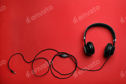 Preview: Stylish modern headphones with earmuffs on color background, top view. Space for text