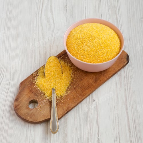 Preview: Organic Masarepa corn meal in a pink bowl over white wooden surface, high angle view.