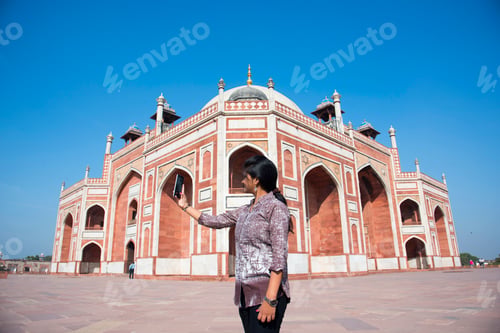 Preview: Indian woman taking selfie with smartphone in front of Humayun's Tomb