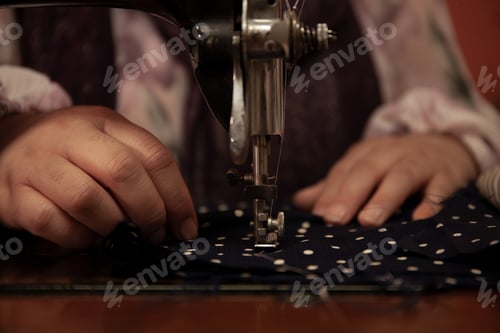 Preview: A woman's hands sew a piece of fabric with a sewing machine.
