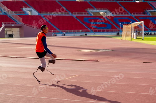 Preview: Asian para-athletes with prosthetic blades sprint on a running track at stadium.