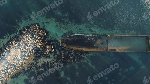 Preview: Aerial view of the rusty sunken ship stuck on a rocky shoal. Shot. Old seagoing vessel