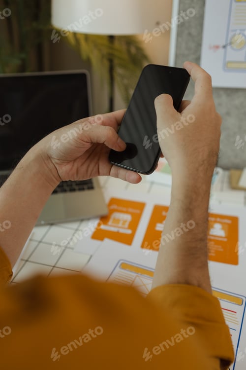 Preview: Hands Hold Phone Above Office Desk With Laptop