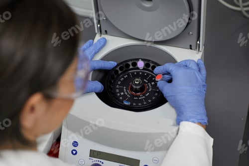 Preview: Attractive female scientist examinine testing bio material with medical equipment bloody spinning