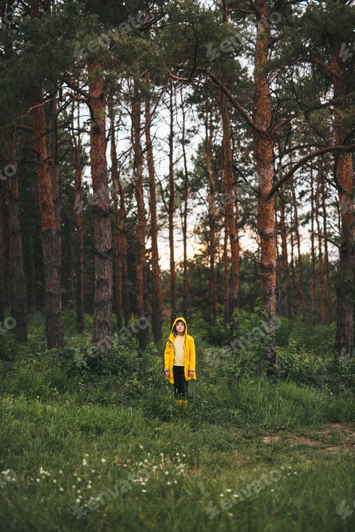 Preview: Kid in raincoat in green forest