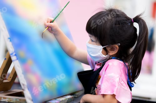Preview: Girl made water painting art in class. Children wear white masks to prevent the spread of virus.