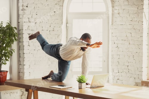 Preview: Young african-american man doing yoga at home while being quarantine and freelance working