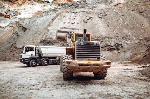 Preview: Wheel loader bulldozer with blade loading dumper trucks on construction site