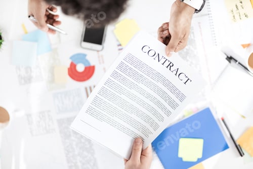 Preview: Overhead view of businessmen holding contract above table with papers