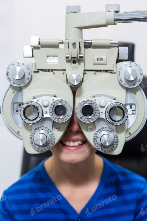 Preview: Young patient looking through phoropter during eye examination