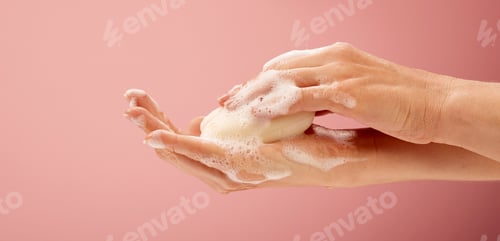 Preview: Close-up shot of hands with soap and foam on bright pink background