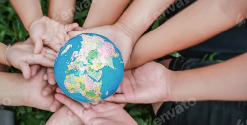 Preview: Closeup children hands holding earth ( blur ) over green grass background