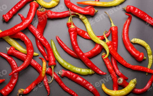 Preview: many green and red hot peppers on black desk