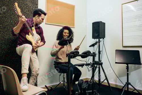 Visualização: Homem tocando guitarra e mulher tocando bateria