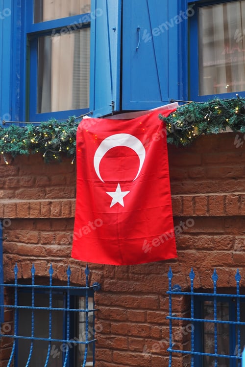 Preview: Turkish flag displayed on blue window in a brick building