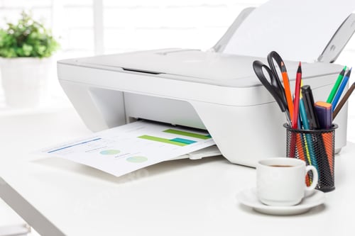 Preview: Printer producing color charts in a bright office setting with desk accessories and coffee cup