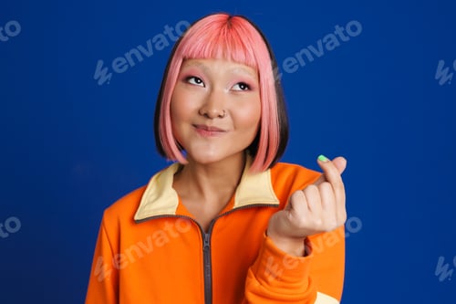 Preview: Asian girl with pink hair laughing while rubbing her fingers