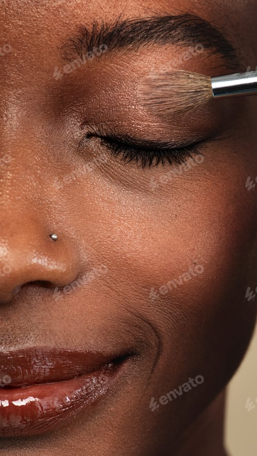 Preview: Makeup artist applying eye shadow on a black woman