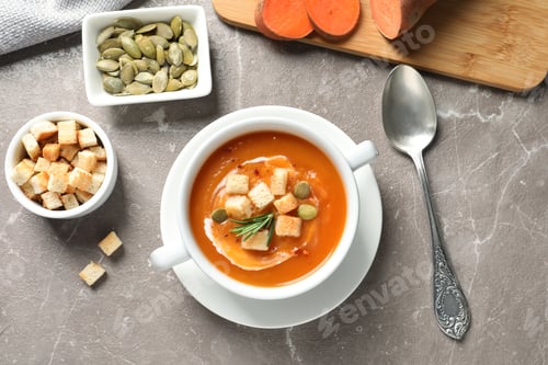 Preview: Flat lay composition with bowl of sweet potato soup on table