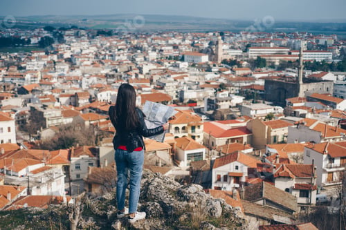 Preview: Young girl standing in front of beautiful city view and looking