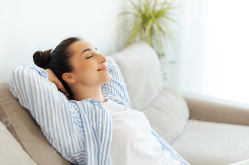 Preview: No stress, relax. Happy calm indian or arabian woman resting on comfortable couch at home alone in