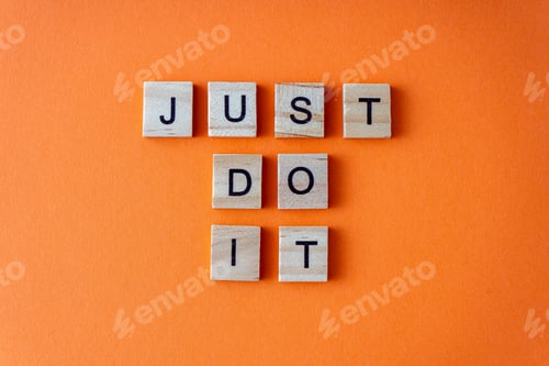 Preview: Just do it word. The phrase is laid out in wooden letters top view. Motivation. Orange flat lay
