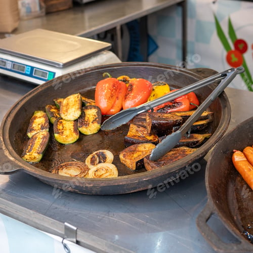 Preview: Grilled vegetables in rustic pan: peppers, zucchini, eggplant, onions on market stall