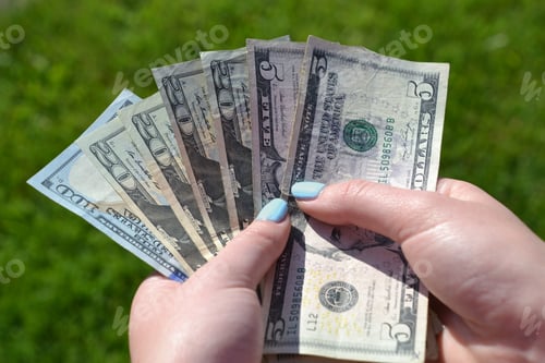 Preview: A female holds a handful of money, cash, currency, economy