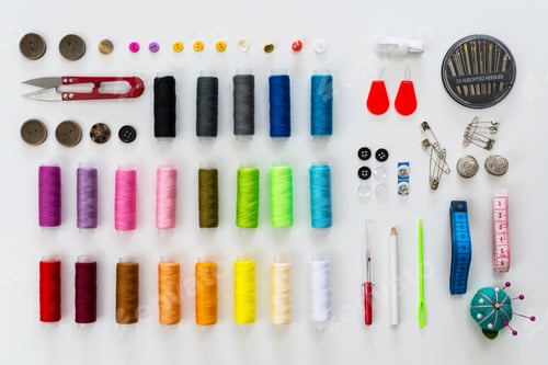 Preview: Flat lay of colorful sewing threads and various sewing equipments