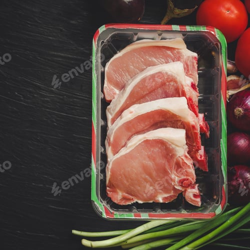 Preview: Steak - A Raw Piece Of Meat Surrounded By Vegetables (Eggplant, Tomato, Onions And Greens)