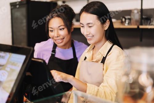 Preview: Two young businesswomen working at the counter of their coffee shop
