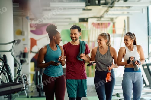 Preview: Multiracial group of happy friends talking after exercising in a gym.