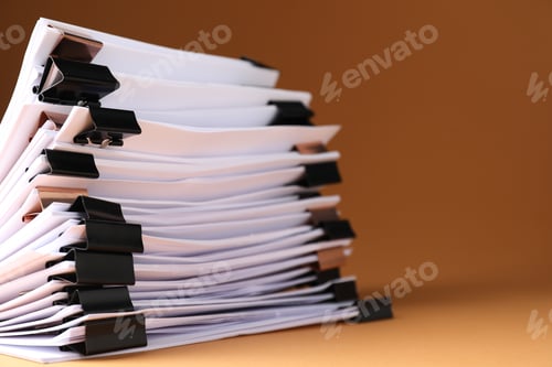 Preview: Many documents with binder clips on brown background, closeup. Space for text