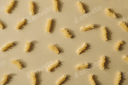 Preview: Top view of spiral pasta pattern. Raw pasta on neutral background, flat lay. Wheat food concept.