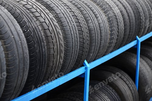 Preview: Rack with variety of car tires in automobile store. Many black tires