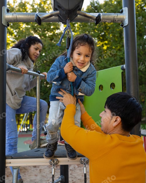 Preview: Latin family with a child playing in a playground. Father helping the kid to jump on a zipline