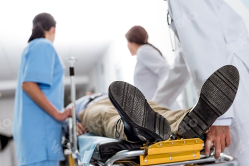 Preview: Doctors and nurse transporting unconscious patient on gurney